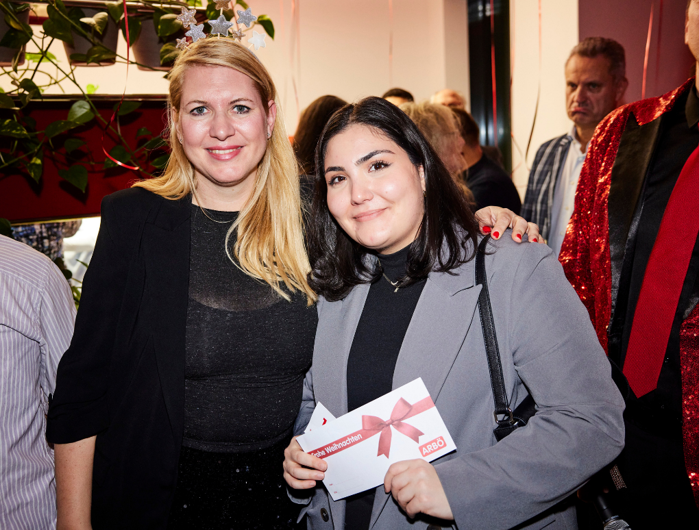 Elisabeth Hakel und ein Gast halten ein ARBÖ Gutschein.