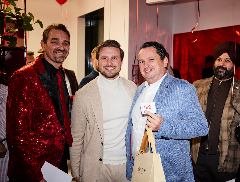 Marko Fischer, Felix Köck und ein Gast halten ein Geschenksackerl von der Schmuckmarke "Von Köck".